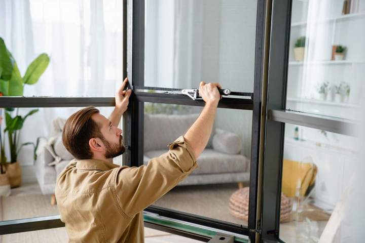 Réparation efficace de moustiquaires pour portes et fenêtres.